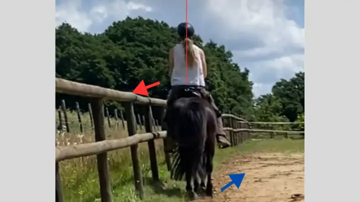 Reiterin sitzt schief im Sattel während Pferd mit der Hinterhand nach innen ausweicht